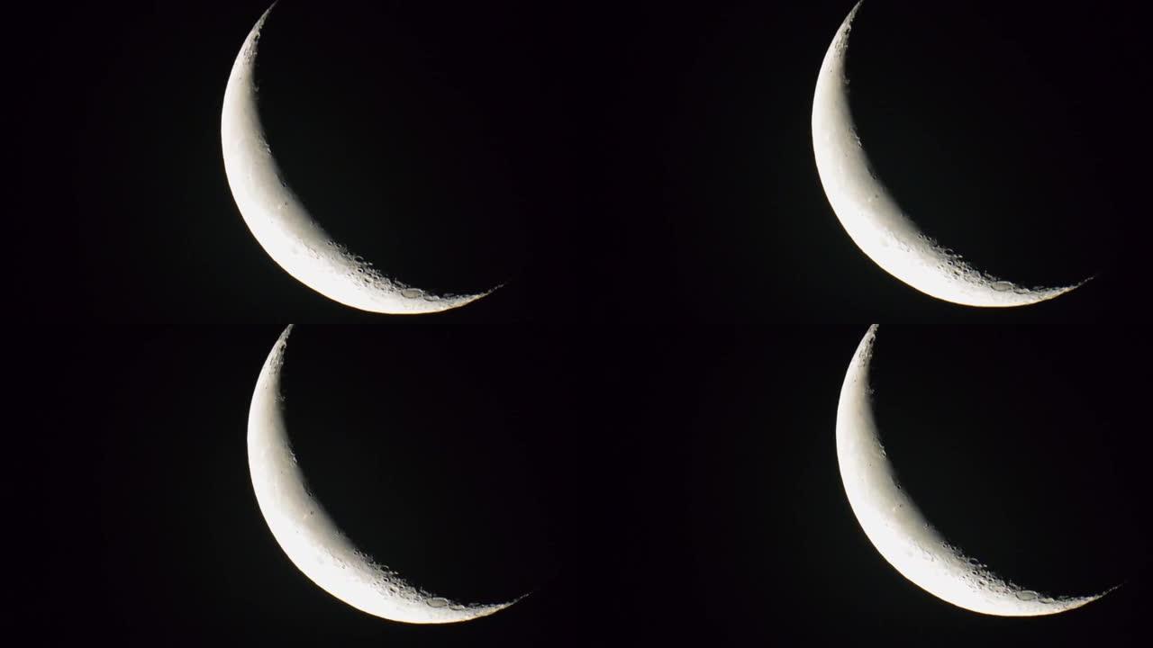 静态视图在万宁新月阶段通过框架移动的天空中的地球卫星月亮。望远镜视野中的宇宙