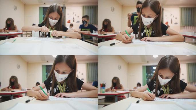 一名戴着防护面罩的女学生在小学美术课上画画