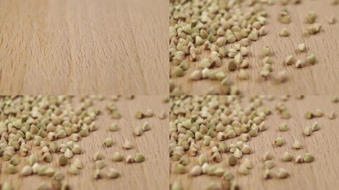 一小撮生熟的荞麦粒落在木表面上
