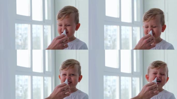 一个3岁的小男孩因流鼻涕被喷在鼻子上。治疗sno。孩子因过敏而滴鼻。