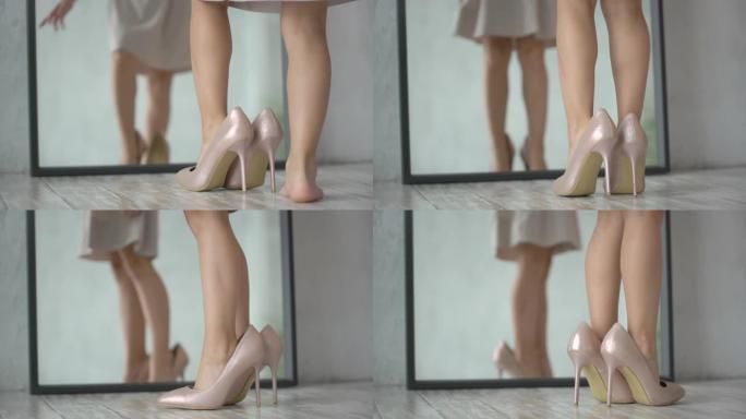 穿着高跟鞋的漂亮小女孩试图在家穿着妈妈的鞋子走路。孩子在镜子前穿着女人的成年妈妈的鞋子。孩子的腿。女