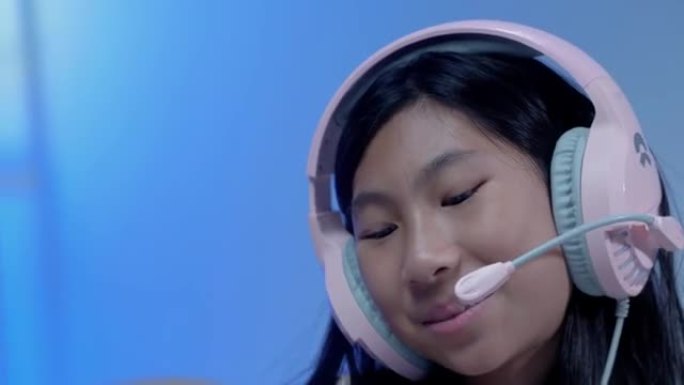快乐的亚洲女孩使用耳机和麦克风通过数字平板电脑与老师和朋友交流，在新型冠状病毒肺炎期间进行家庭教育，