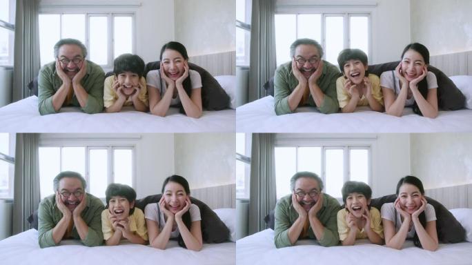 快乐的亚洲家庭可爱，孩子和家庭的概念 -- 快乐的家庭和小儿子在毯子下白色舒适的床上，父母在家