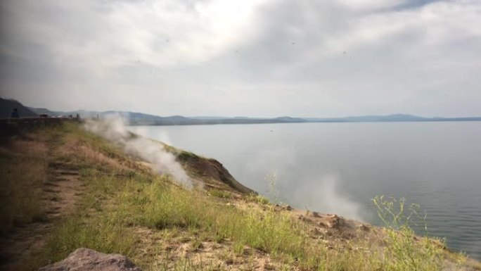 汽船角俯瞰着黄石国家公园黄石湖沿岸的蒸汽喷口冒出的烟雾。