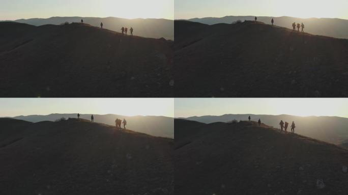 航拍一群观光客在夕阳下走上小山