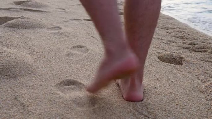 无法识别的男性在沙滩上行走