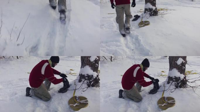 高加索人在冬季森林的树木之间设置松懈线。一个男人在冬天练习高脚板。