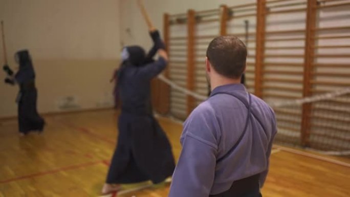 武术老师，在他的剑道课上，观察学生的技术