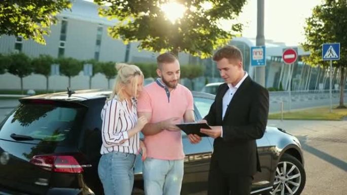 卖家将汽车卖给幸福的年轻夫妇，与推销员签订合同