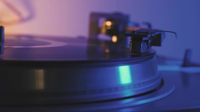 一张黑胶唱片在留声机音乐播放器中旋转，并播放旧的迪斯科舞厅。复古黑胶唱机特写镜头