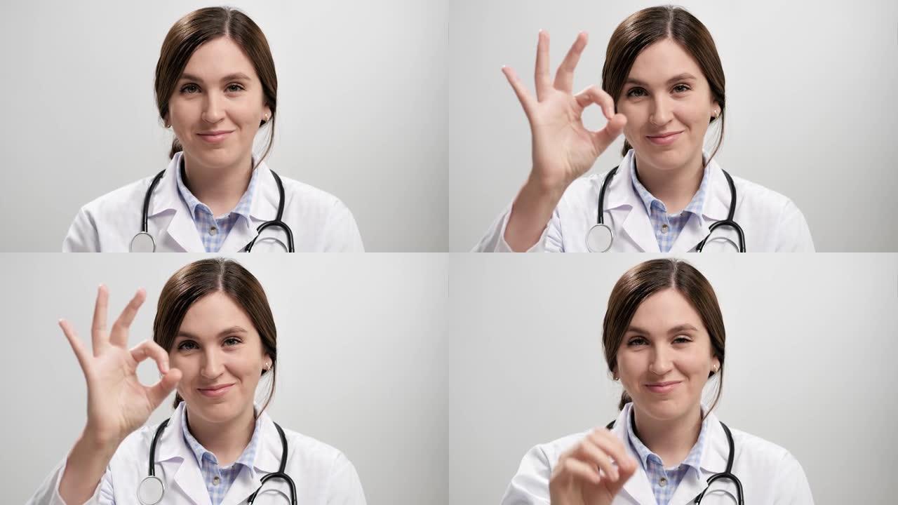 医生显示好了。积极微笑的女医生在灰色背景看相机和手势她的右手显示OK标志。慢动作
