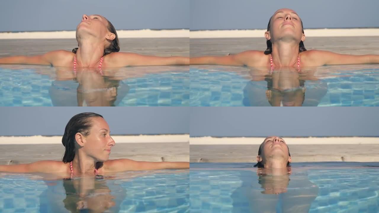 女人在豪华假期在游泳池里放松