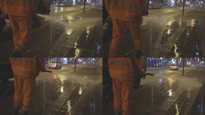 环卫工人用软管清洗城市街道