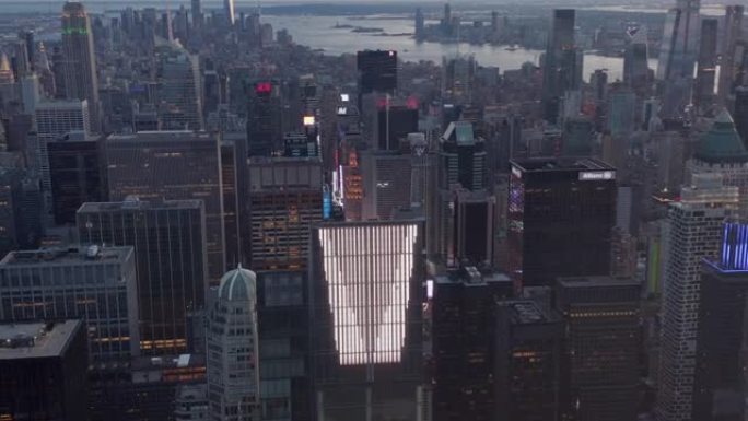 在曼哈顿天际线被高楼包围的现代未来派新摩天大楼上方，向上倾斜，揭示了日落时纽约市令人叹为观止的城市景