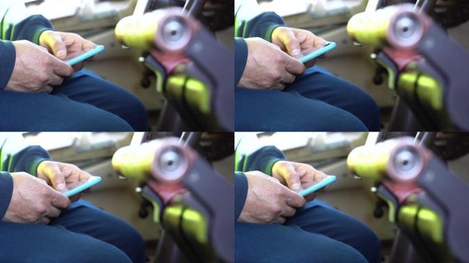特写，在商用飞机的驾驶舱中使用智能手机的成年男性双手的侧视图。