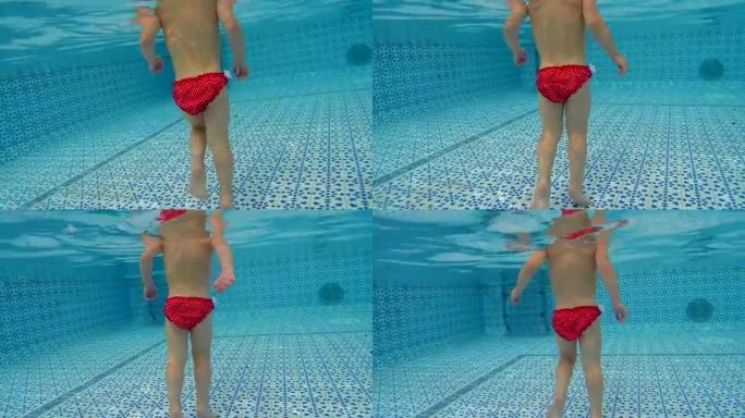 水下的婴儿脚。这个孩子学会了游泳。水中的台阶在游泳池里射击。那个女孩在水里跑。