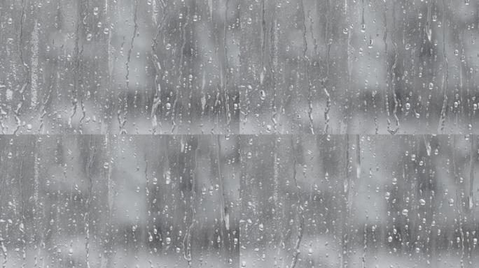 水滴溅到玻璃上。雨天的窗户。湿玻璃，有大滴水或雨水。大雨时在透明玻璃表面上的水滴视频。滴水