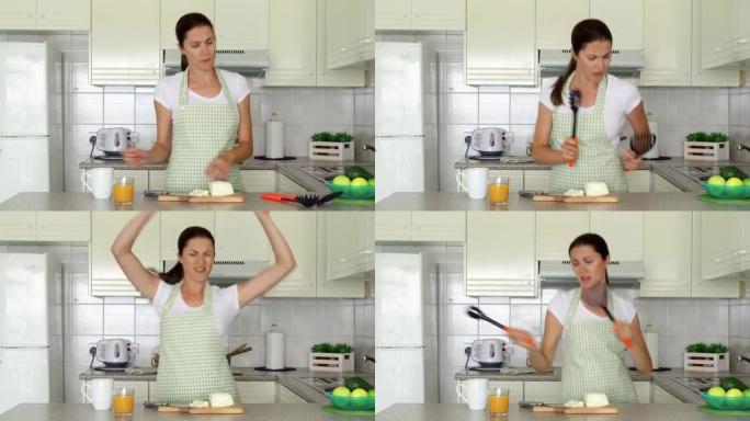 女人在厨房里傻跳舞。有趣的女性在准备饭菜时享受着可笑的动作