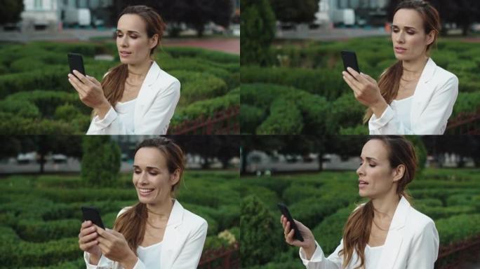 友好的女商人在city walk的智能手机上通过视频通话讲话。