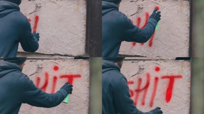街头流氓用喷漆在墙上写字