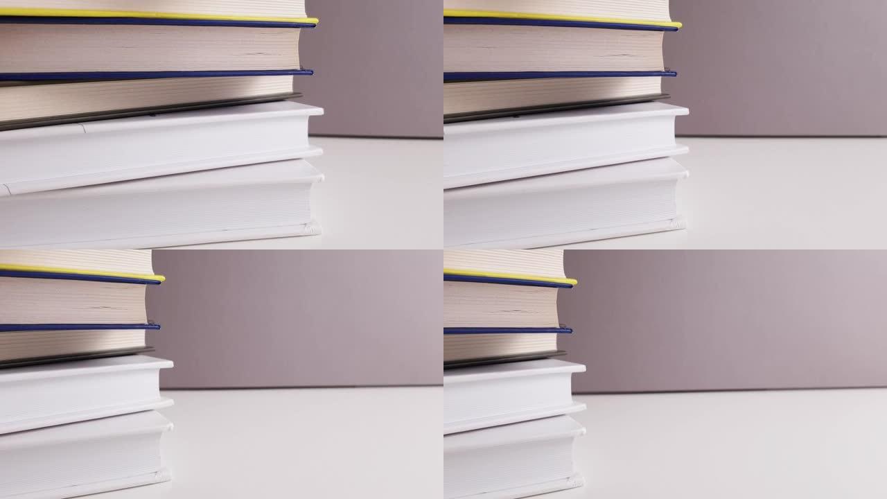 书籍堆积不同的颜色在白色灰色背景和框架上移动远离书籍教育学习学校学习研究概念与复制空间。