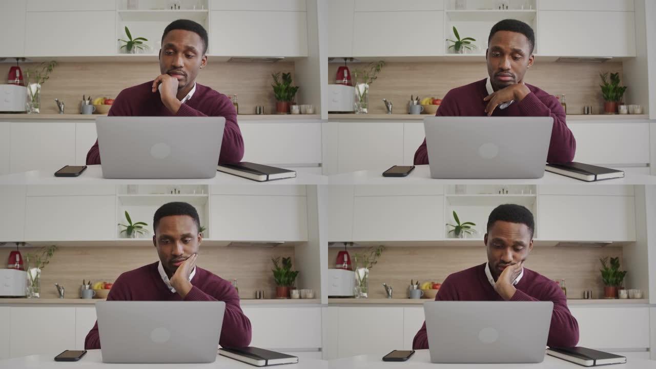 年轻的黑人在笔记本电脑上在家工作时找不到舒适的姿势