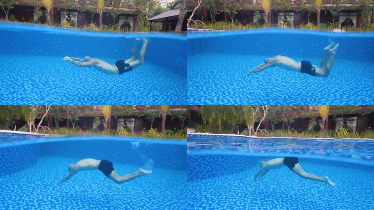 一个男人在游泳池里像美人鱼一样游泳的水下照片。