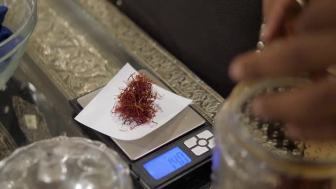 马拉喀什药草商店中用于减肥茶和健康低脂烹饪草药的红花藏红花秤重量