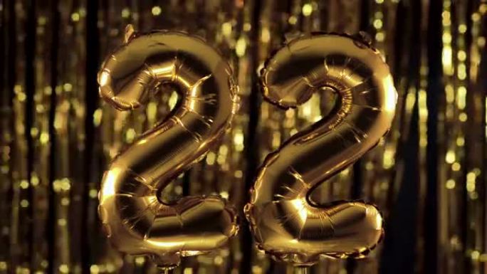 金色数字22 22由充气气球制成，在黄色背景上。一组完整的数字。生日、周年纪念日、日期的概念