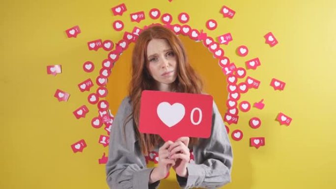 沮丧的女性博客作者持有一个心脏标志，她有零喜欢，她建议点击心脏按钮，在社交网络上放一个喜欢，孤立的黄