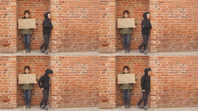 无家可归的孩子在街上乞丐，纸板上有社交信息，遭受贫困和孤独