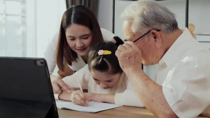 女孩在家用平板电脑在线学习。她给母亲和祖父看作业。在线学习理念。