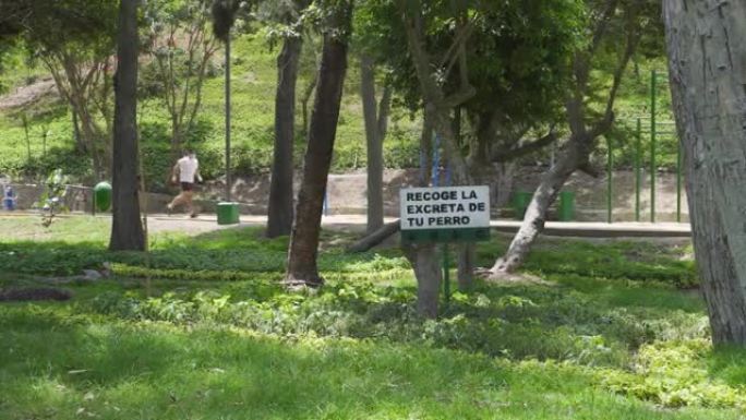 嵌入公园的标志，上面写着 “收集狗的粪便”