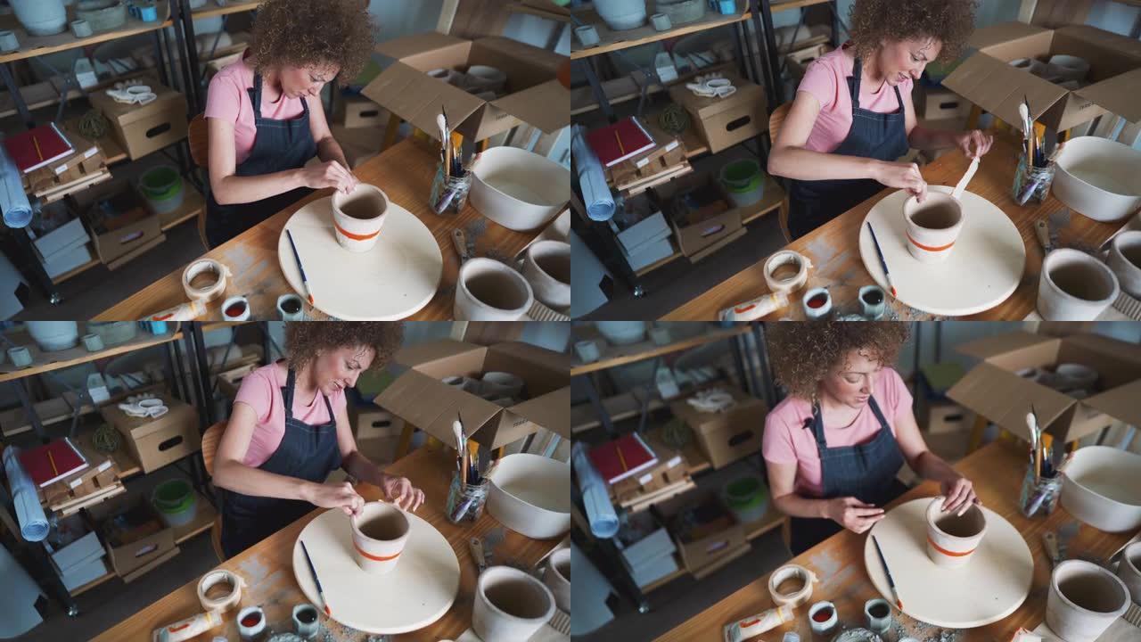 一名手工艺人在她的陶器工作室里拆除了胶带混凝土花盆
