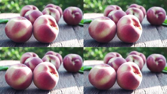 模糊花园背景下的新鲜桃子水果，花园木桌上的竹篮中的桃子。