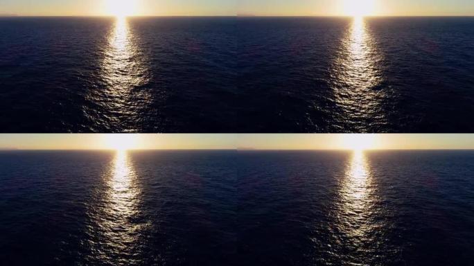 帆船在夕阳下的海中航行。我们可以看到整个地平线上的船和水以及水中光线的反射4K