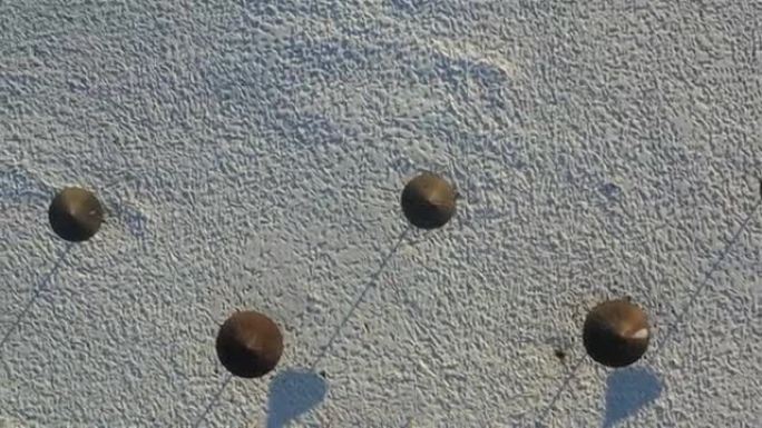冬天海滩的俯视图，雪地里的脚印，蘑菇的阴影。无人机上的照片。