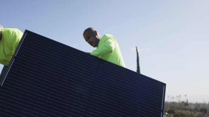 在加利福尼亚州的住宅屋顶上安装太阳能电池板的工人团队