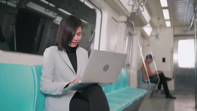 女商人在空中火车或地铁上使用笔记本电脑工作，他们的工作方式运输人们的生活方式和无线连接概念。