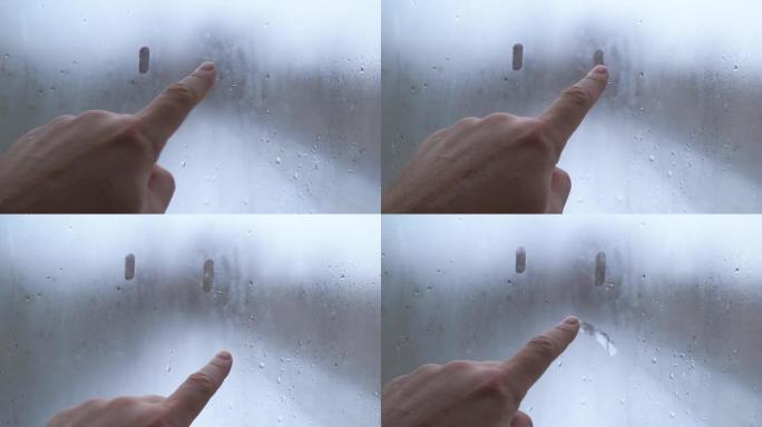 手在雾蒙蒙的玻璃上画了一张悲伤的脸。孤独和悲伤的象征