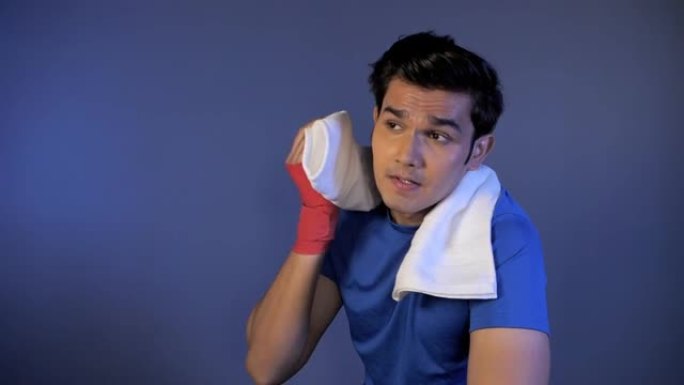 上大学的印度男性在健身房锻炼后用毛巾擦拭汗滴