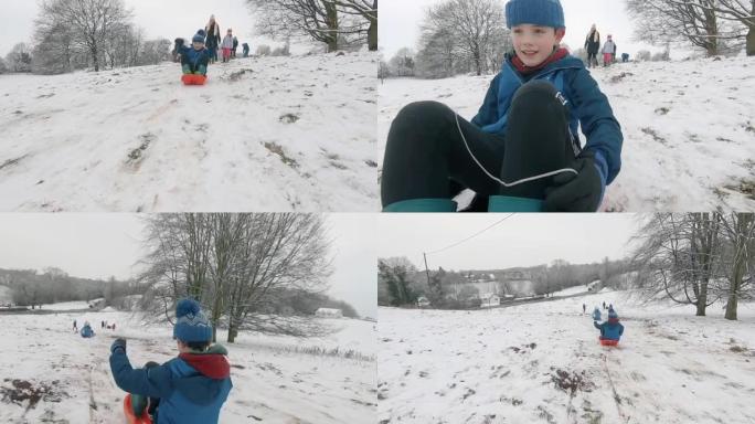 在英国乡村的一座小山上，家庭在新鲜的雪中雪橇