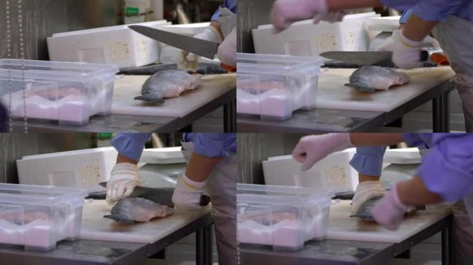 日本男子清洗并准备鲑鱼在筑地鱼市场出售。