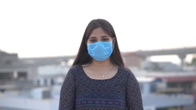 年轻的亚洲妇女戴着口罩对抗科罗娜病毒。