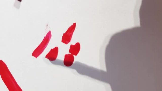 4k视频，在白色背景上使用修指甲刷的红色指甲油的彩色笔触