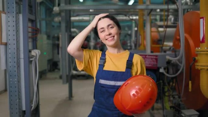 现代工业和制造业。一位年轻的高加索女工程师的肖像，她脱下防护头盔并微笑。相机向脸部移动