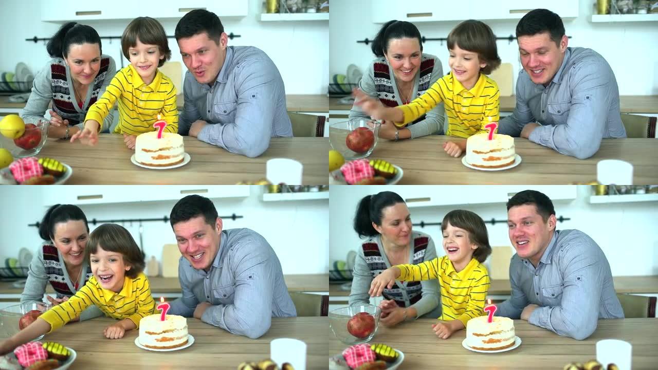 厨房里有趣的小男孩和父母一起玩水果。非常可爱的男孩用蛋糕庆祝他的生日 & 快乐的父亲和母亲。迷人的父
