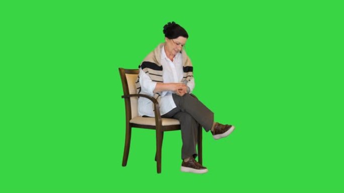 成熟的女人使用血压测量装置，在绿色屏幕上感觉良好，色度键