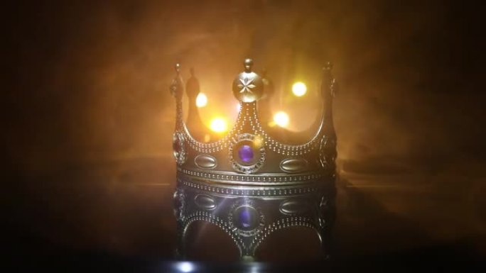 木桌上美丽的女王/国王皇冠的低调形象。复古过滤。幻想中世纪时期。选择性聚焦。彩色背光