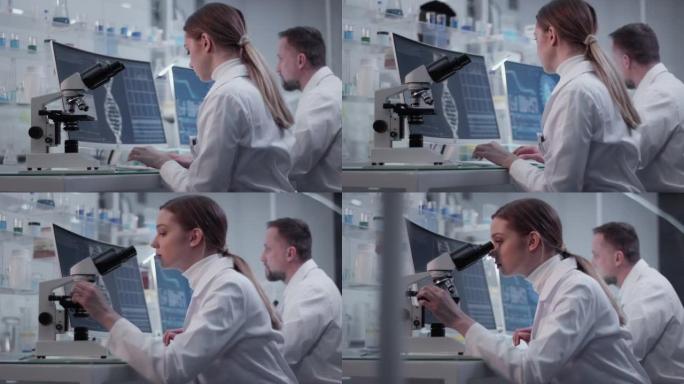 研究医学样本的多样化科学家。使用计算机和显微镜。现代实验室室内
